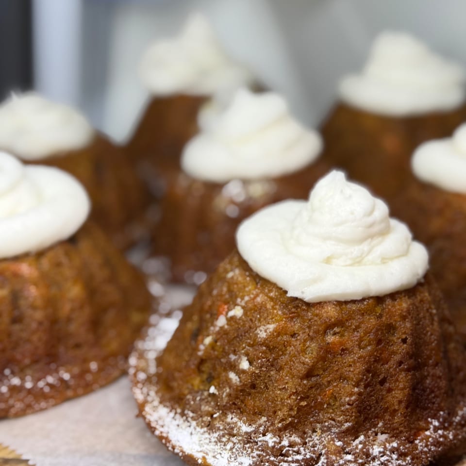 Chocolate cupcakes topped with swirls of white frosting and dusted with powdered sugar.